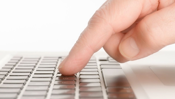 Ein Finger in Nahaufnahme über einer Tastatur