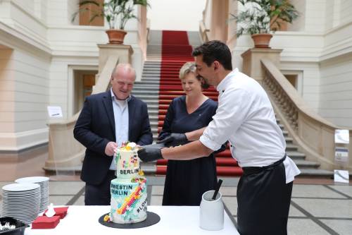 Präsidentin Cornelia Seibeld und der Leiter des schwulen Anti-Gewalt-Projekts MANEO Bastian Finke schneiden den Regenbogenkuchen an